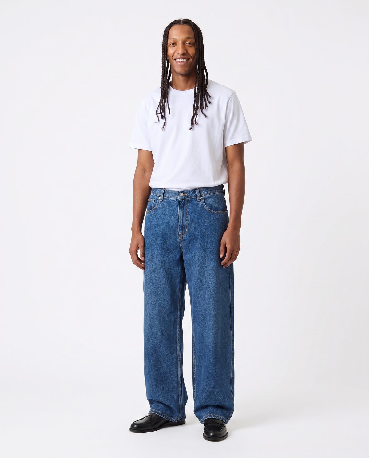 Jean bleu coupe large porté avec un t-shirt blanc